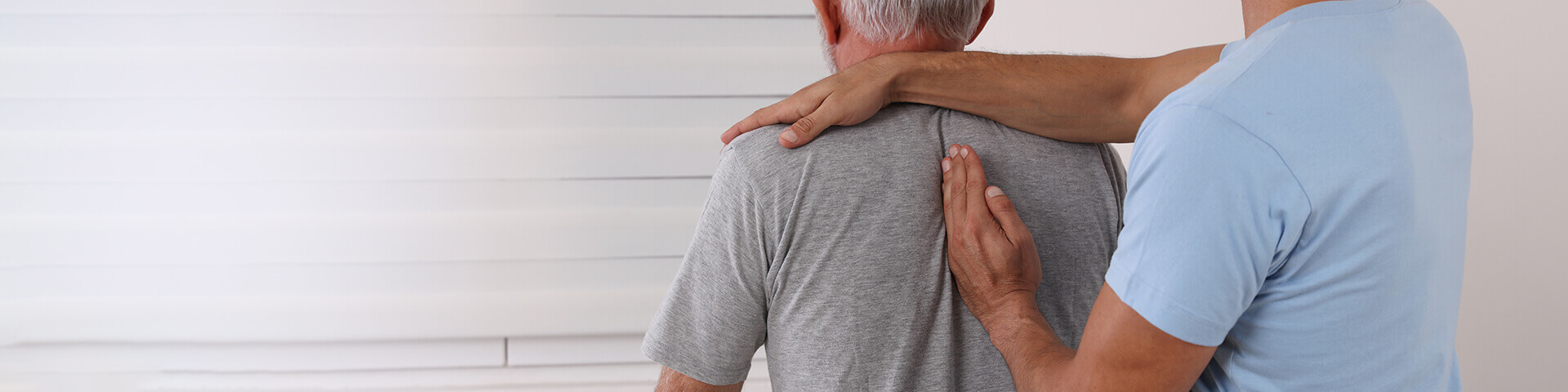 Chiropraktiker / Osteopath behandelt den Rücken eines älteren Patienten