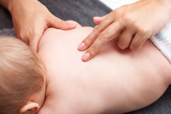 Wirbelsäule eines Babys wird von einem Osteopath oder Physiotherapeut behandelt.